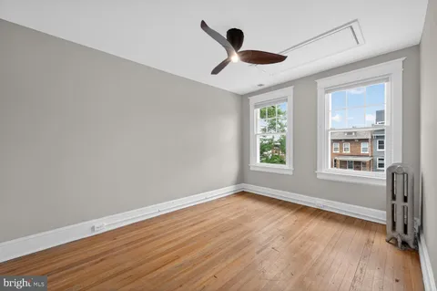 a view of empty room with wooden floor