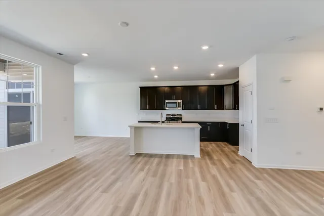 a view of kitchen with kitchen island sink and refrigerator