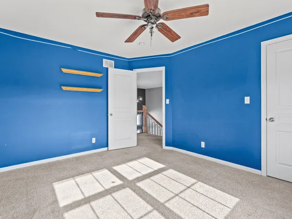 a view of a livingroom with a chandelier fan and a workspace