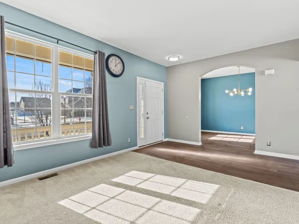 a view of an empty room with wooden floor and windows