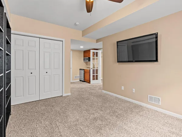 a view of an empty room with window and chandelier fan