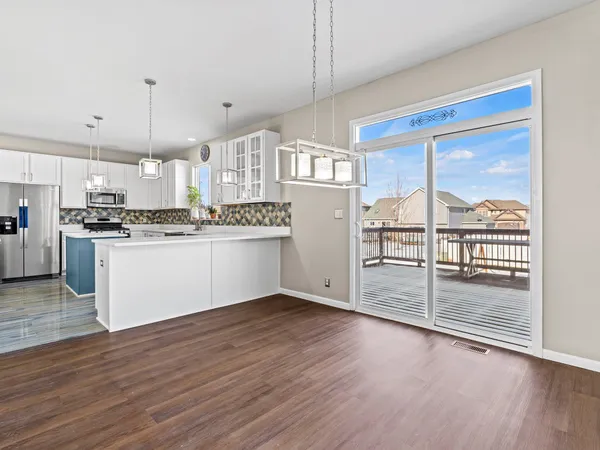 a kitchen with stainless steel appliances granite countertop a stove top oven a sink with a dining table and chairs