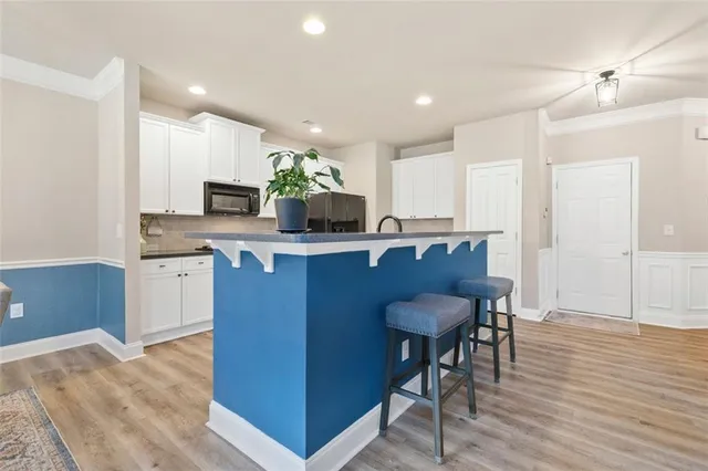 a kitchen with a table chairs refrigerator and cabinets