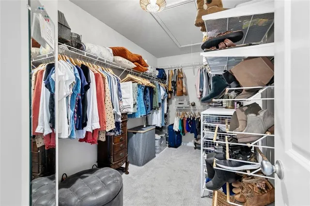 a view of walk in closet with clothes and shoes