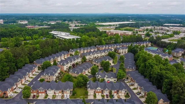 an aerial view of residential houses with outdoor space and trees