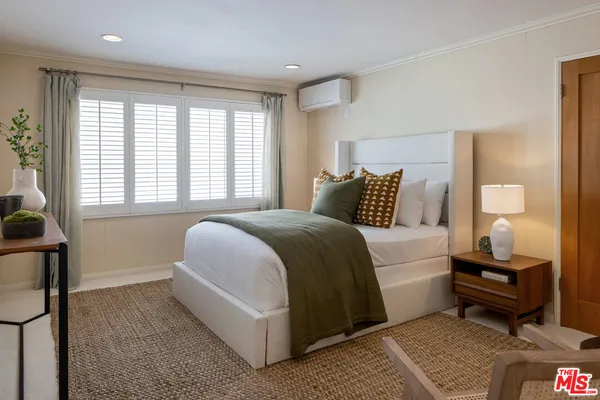 a bedroom with a bed and a mirror