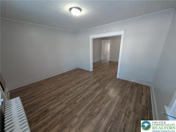 a view of an empty room with wooden floor