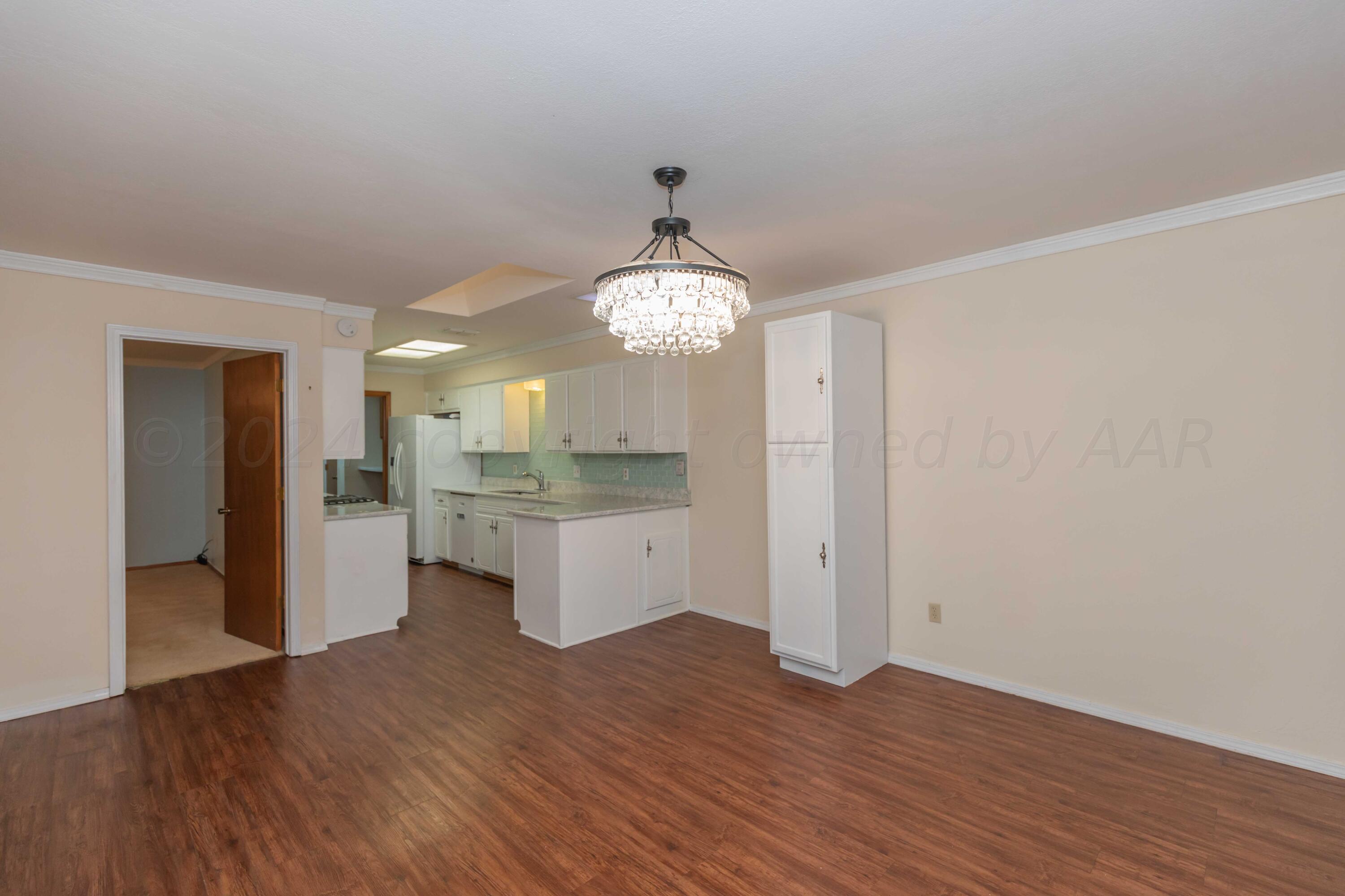 3406 Gladstone Lane Amarillo, TX 79121 - Photo 14 of 35 a view of a kitchen with wooden floor and a refrigerator