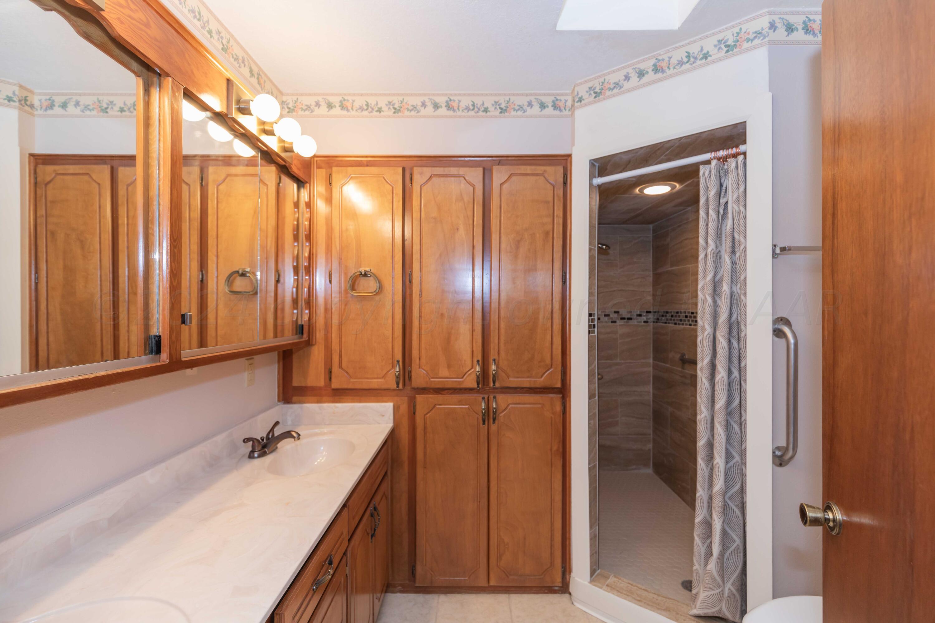 3406 Gladstone Lane Amarillo, TX 79121 - Photo 24 of 35 a bathroom with a double vanity sink and mirror