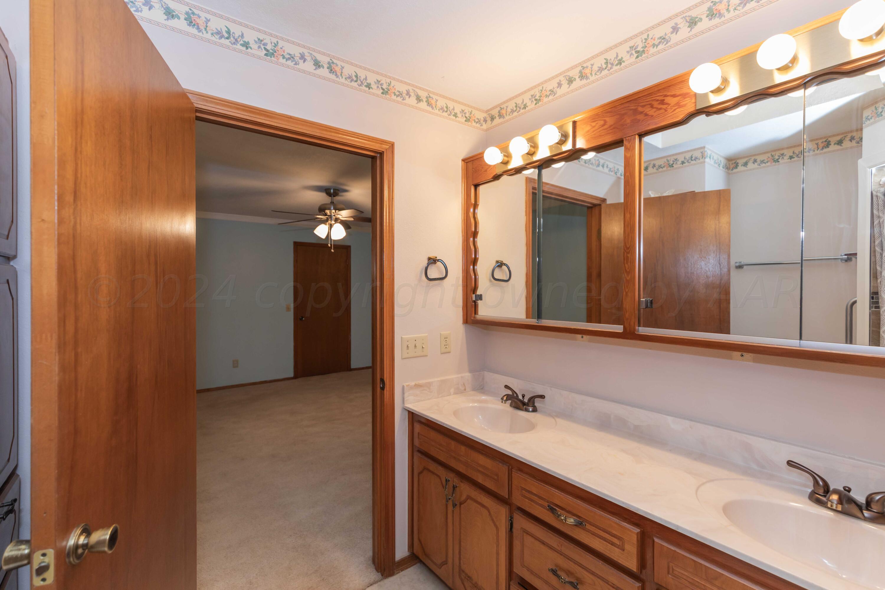 3406 Gladstone Lane Amarillo, TX 79121 - Photo 25 of 35 a bathroom with a sink and a large mirror