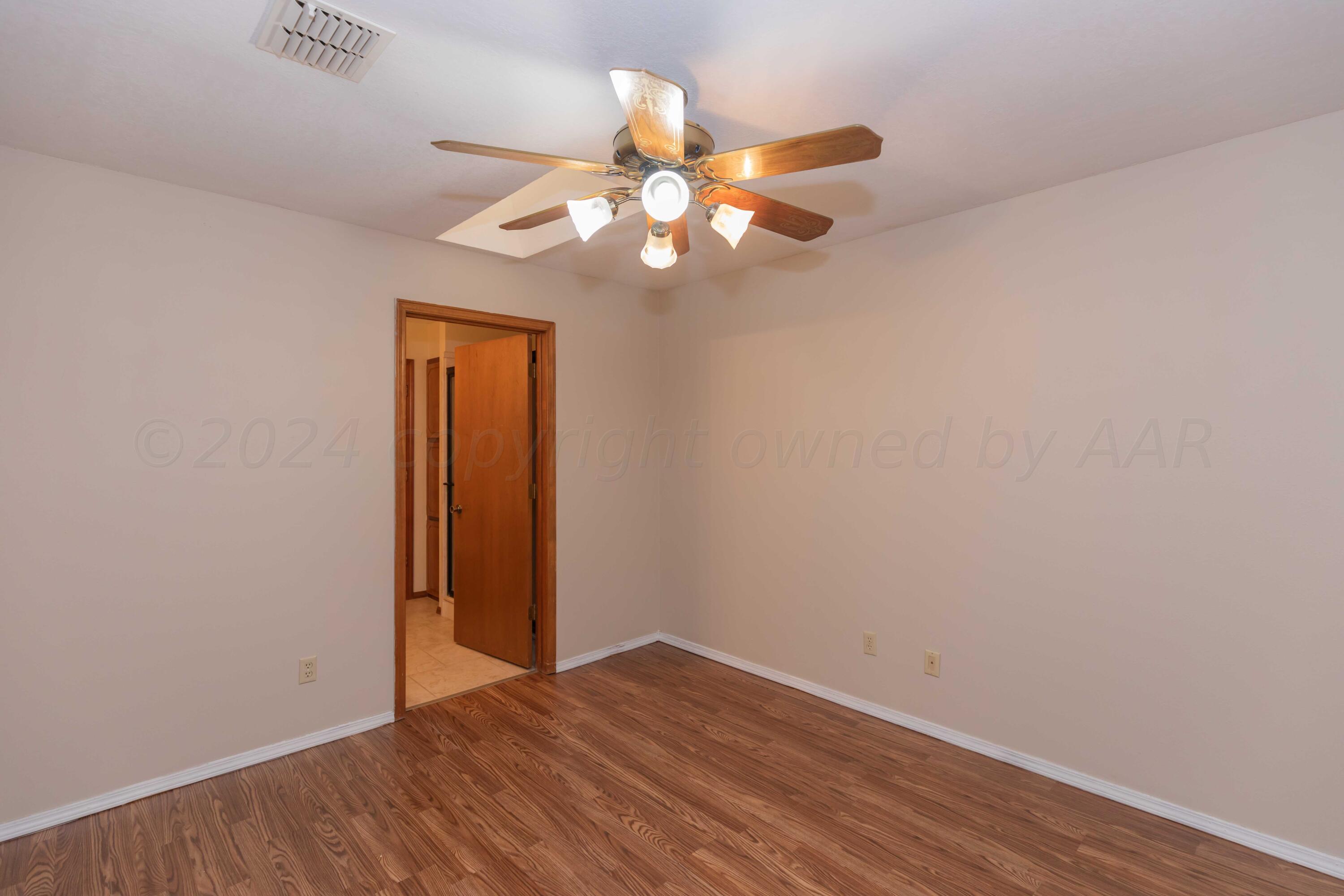 3406 Gladstone Lane Amarillo, TX 79121 - Photo 29 of 35 a view of an empty room with wooden floor and a ceiling fan