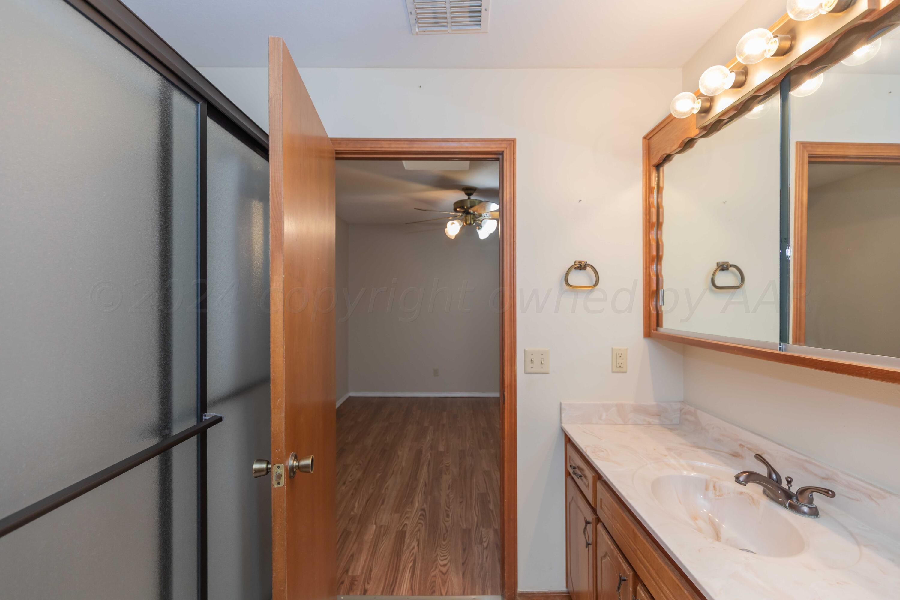 3406 Gladstone Lane Amarillo, TX 79121 - Photo 31 of 35 a bathroom with a sink and a mirror