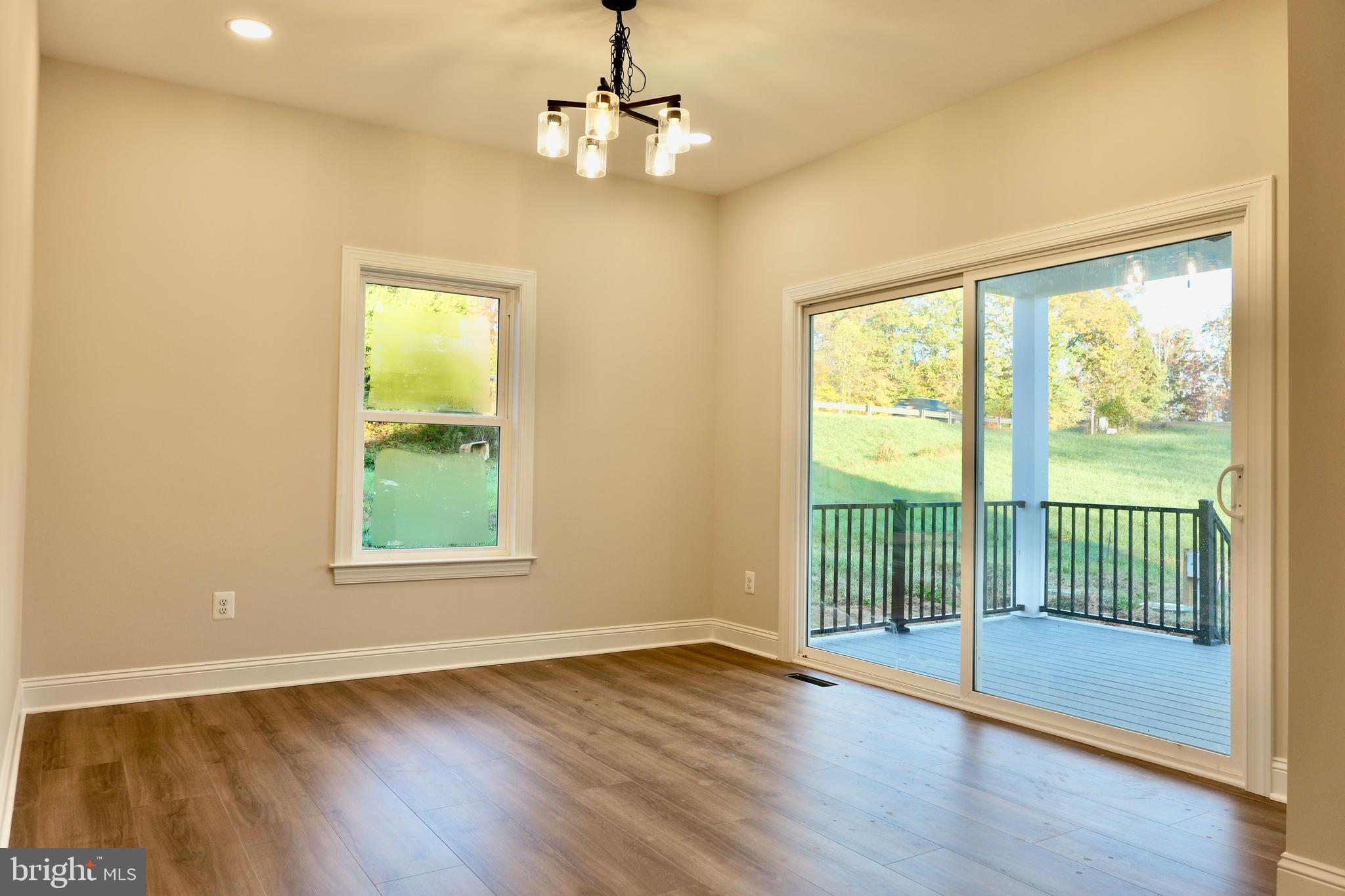 8028 Pinnacle Ridge Drive Manassas, VA 20112 - Photo 26 of 74 a view of an empty room with wooden floor and a window