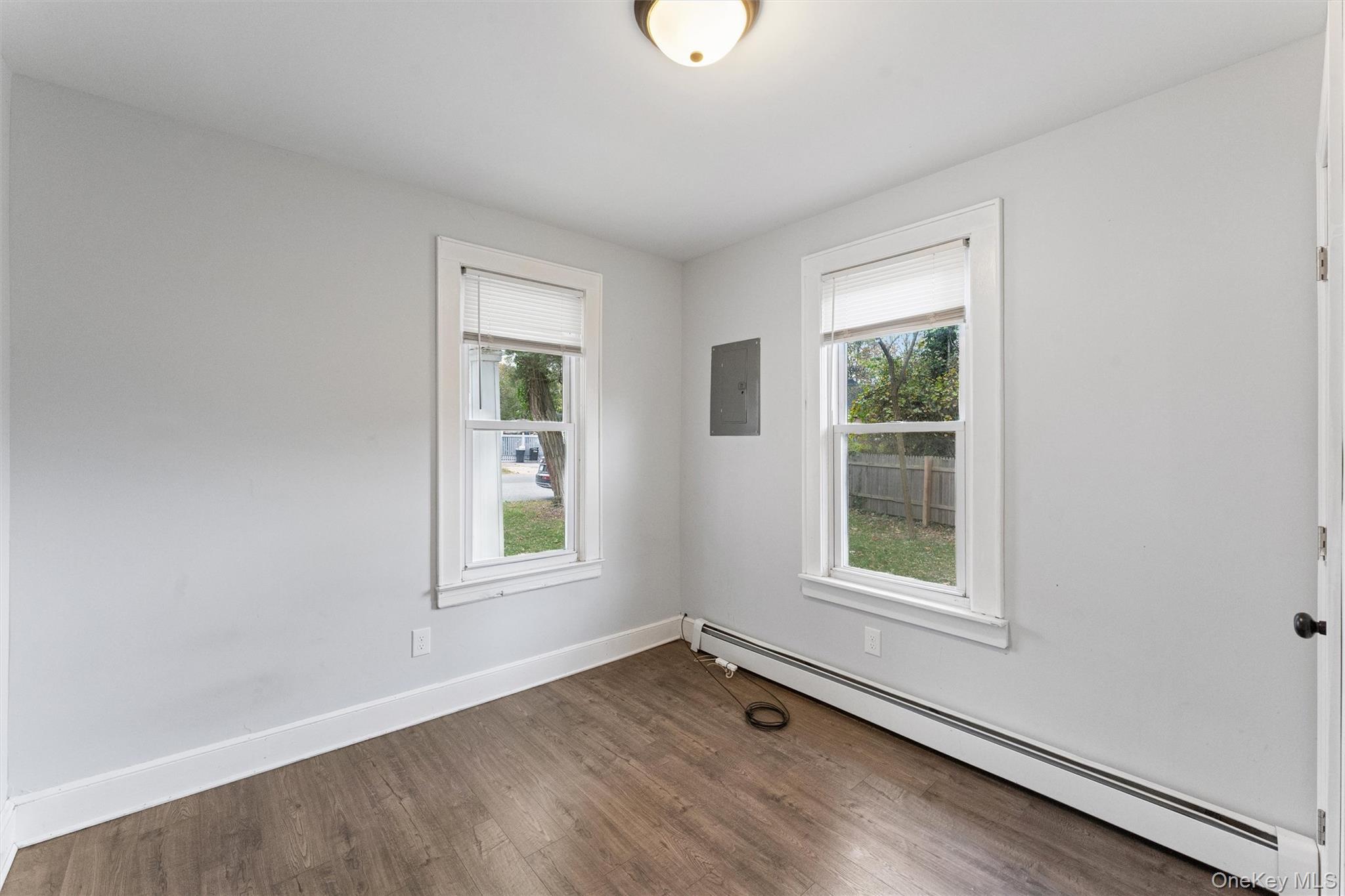 242 Bayview Drive Mastic Beach, NY 11951 - Photo 12 of 18 an empty room with wooden floor and windows