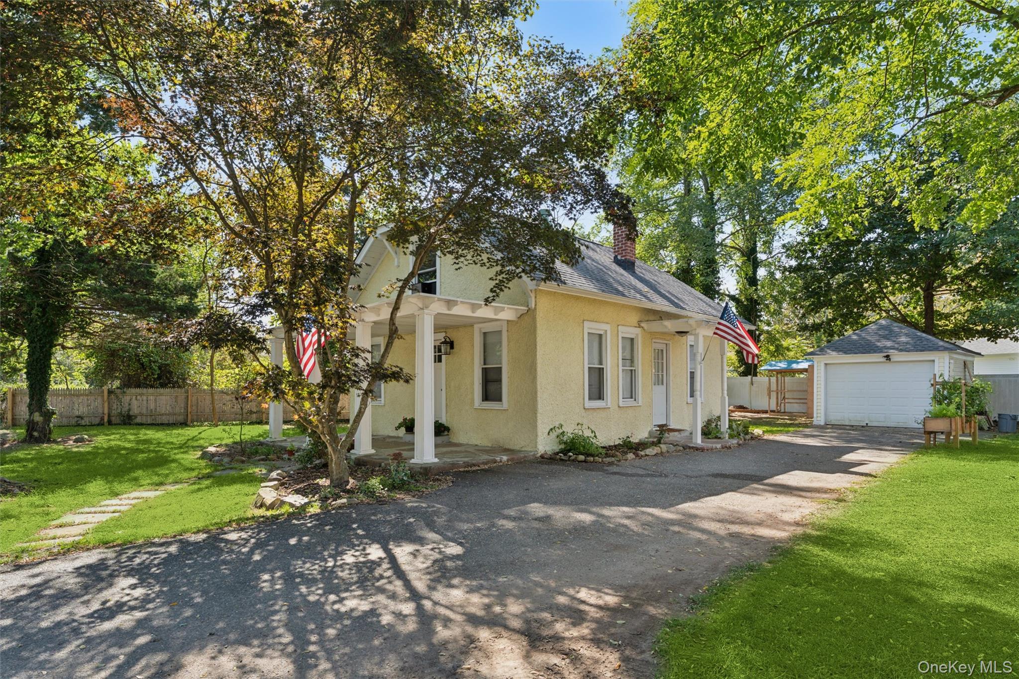 242 Bayview Drive Mastic Beach, NY 11951 - Photo 15 of 18 a front view of a house with a yard and trees