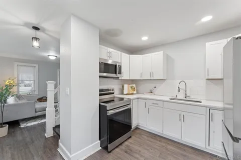 a kitchen with white cabinets and appliances