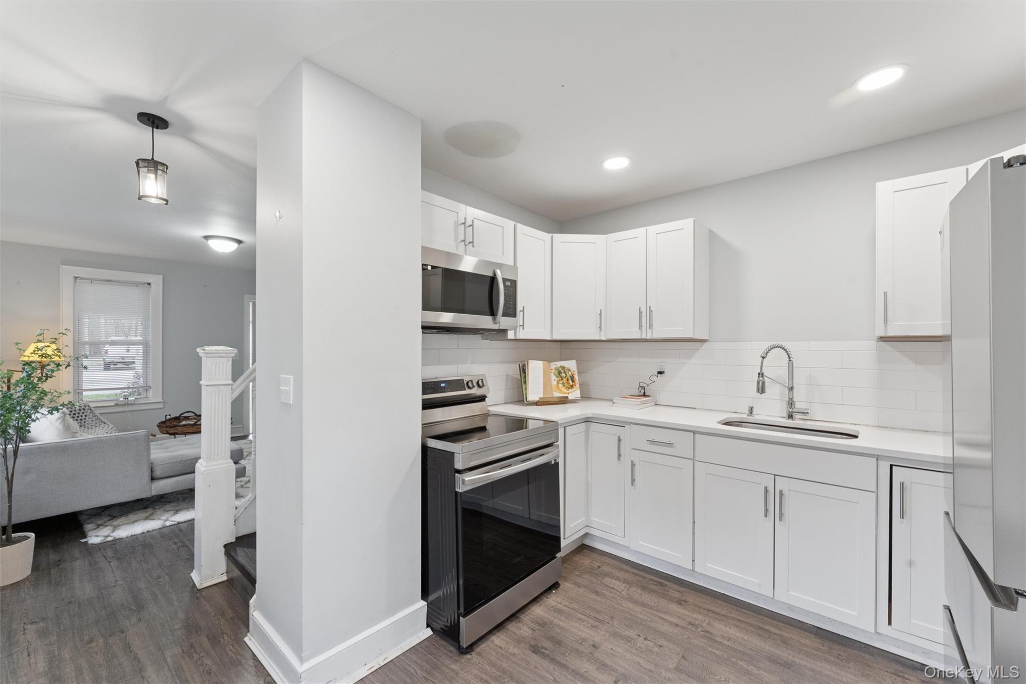 242 Bayview Drive Mastic Beach, NY 11951 - Photo 4 of 18 a kitchen with white cabinets and appliances