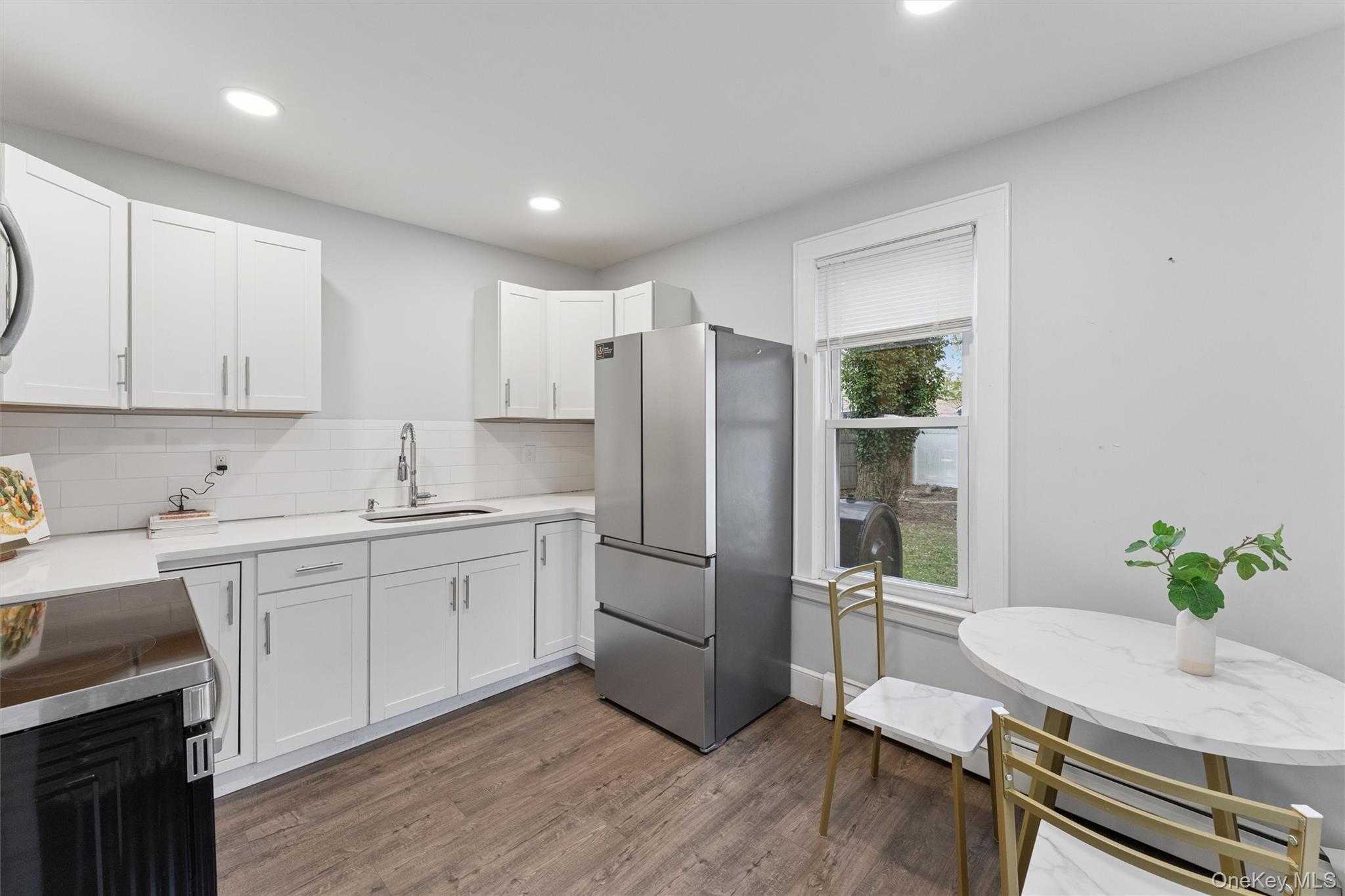 242 Bayview Drive Mastic Beach, NY 11951 - Photo 5 of 18 a kitchen with stainless steel appliances granite countertop a refrigerator sink and stove