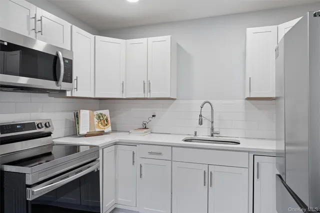 a kitchen with stainless steel appliances granite countertop a sink a stove a microwave and cabinets