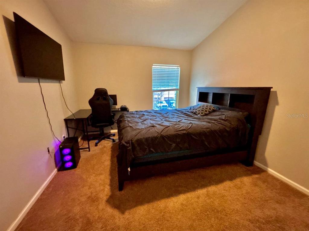 26618 Castleview Way Wesley Chapel, FL 33544 - Photo 14 of 29 a bedroom with a bed tv and a window