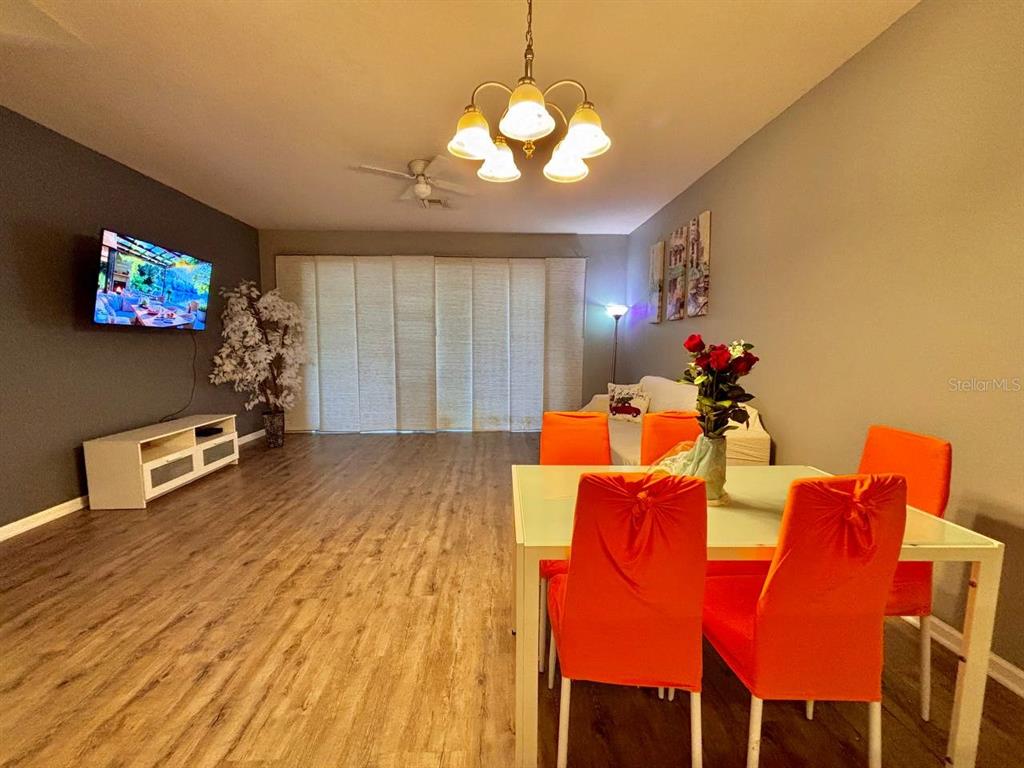 26618 Castleview Way Wesley Chapel, FL 33544 - Photo 4 of 29 a living room with dining room and a flat screen tv