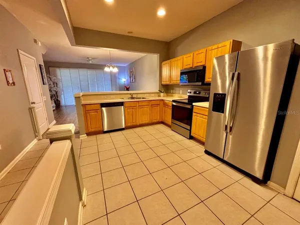a kitchen with stainless steel appliances a refrigerator sink and microwave