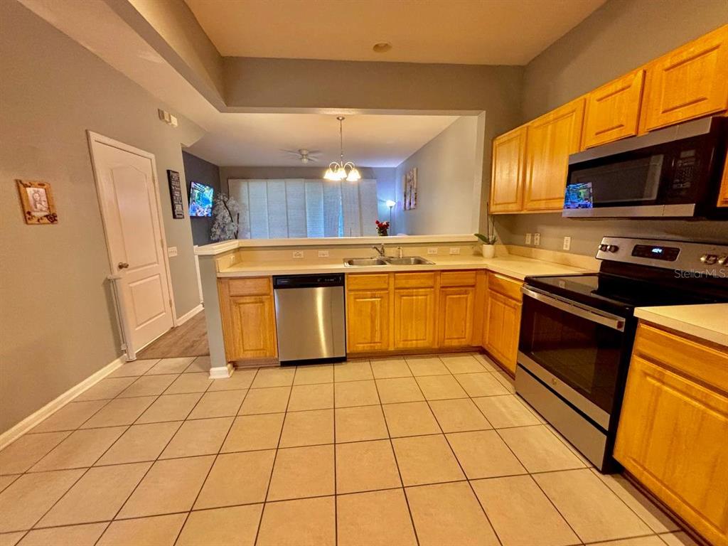 26618 Castleview Way Wesley Chapel, FL 33544 - Photo 6 of 29 a kitchen with stainless steel appliances granite countertop a stove a sink and a refrigerator