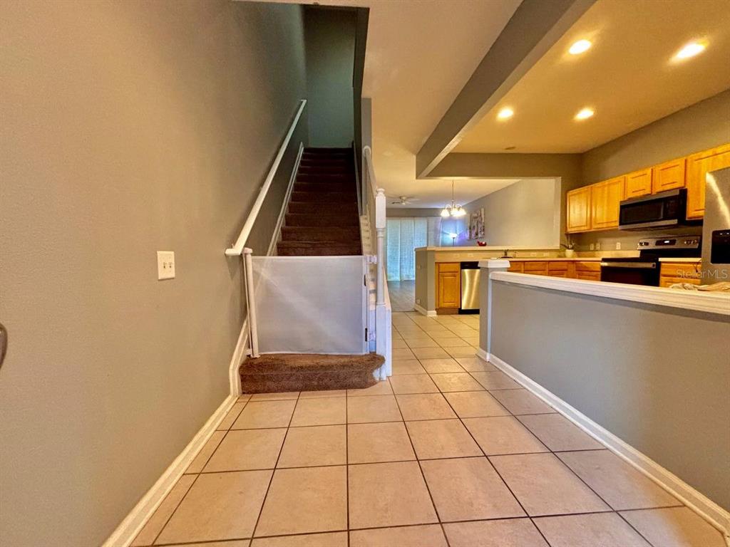 26618 Castleview Way Wesley Chapel, FL 33544 - Photo 7 of 29 a kitchen with stainless steel appliances a refrigerator a stove a microwave and a dining table