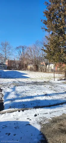 a view of a yard with wooden fence