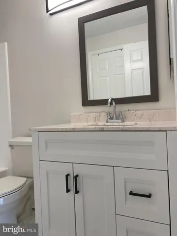 a bathroom with a toilet sink and mirror