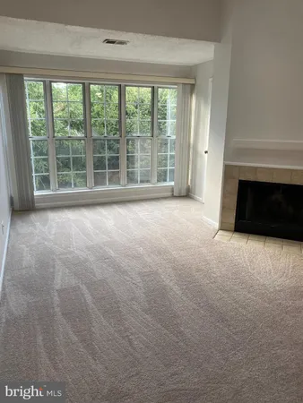a view of an empty room with a fireplace and a large window