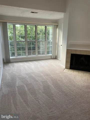 a view of an empty room with a fireplace and a large window