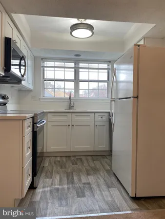 a kitchen with kitchen island a counter top space a sink and a refrigerator