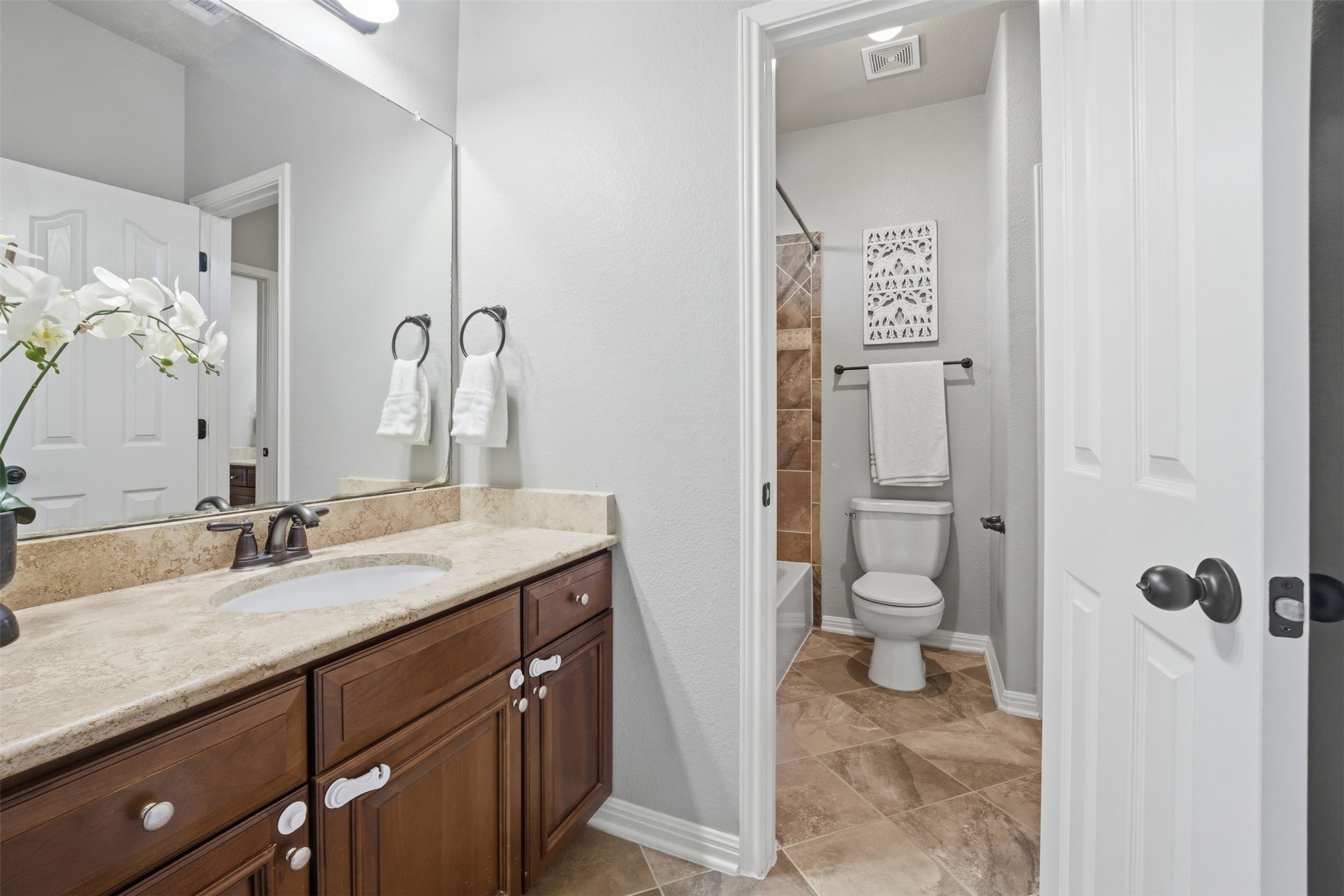 16100 Spillman Ranch Loop Austin, TX 78738 - Photo 32 of 39 a bathroom with a granite countertop sink a mirror and a toilet