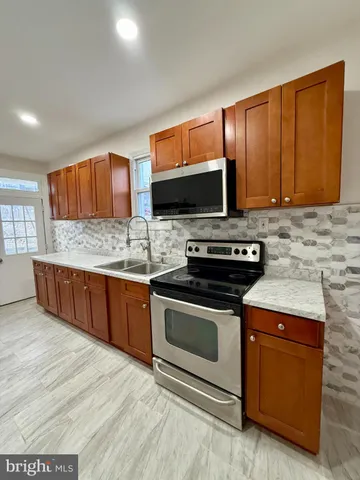 a kitchen with stainless steel appliances a stove microwave and sink