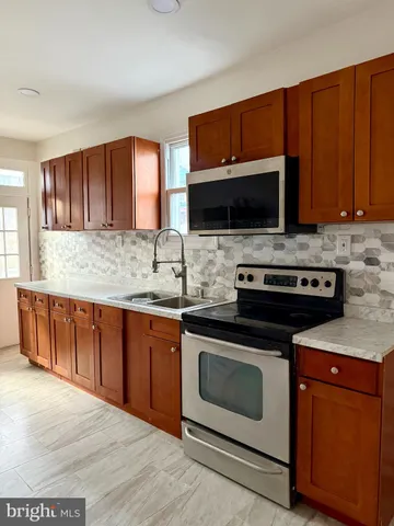 a kitchen with granite countertop a stove top oven microwave and cabinets