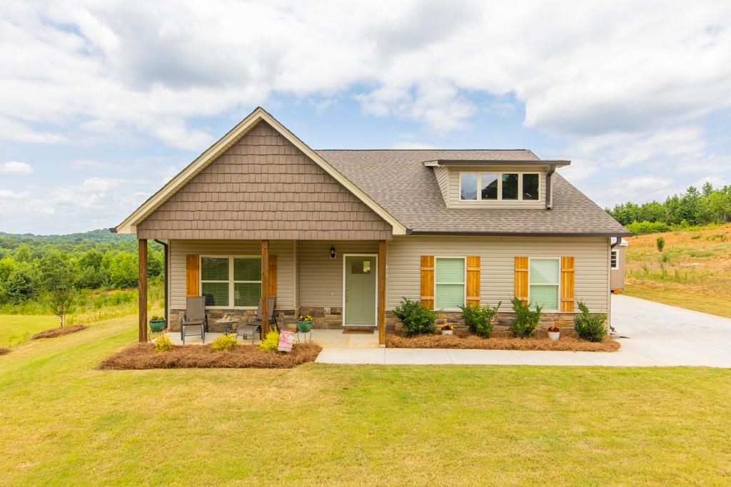 a front view of house and yard with swimming pool and seating