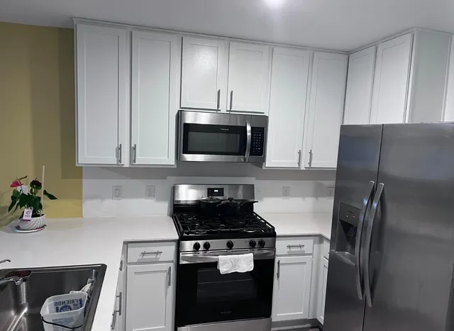 a kitchen with stainless steel appliances granite countertop a refrigerator sink and stove