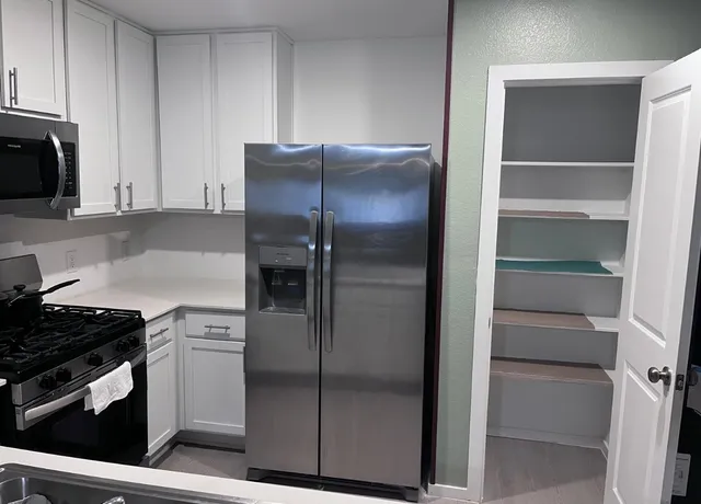a kitchen with a refrigerator and a stove top oven