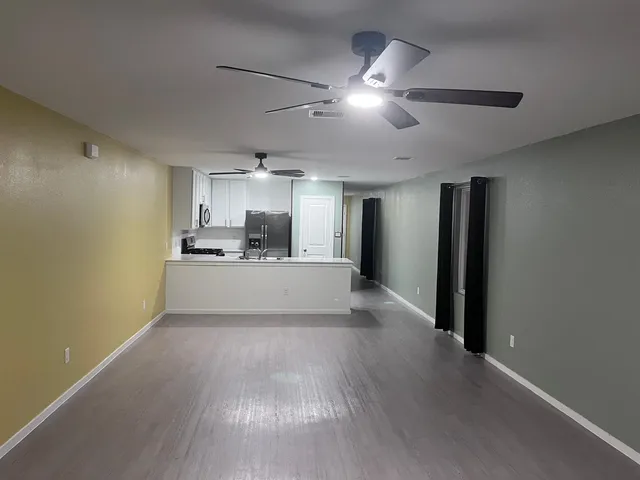 a view of a kitchen with a sink and a refrigerator