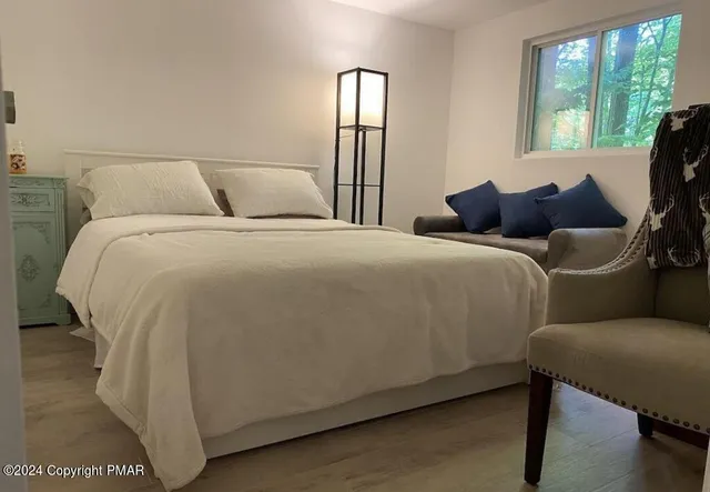 a bedroom with a bed mirror and window