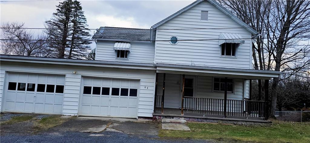a view of a white house with large windows and a small yard