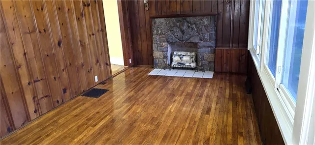 a hallway with wooden floor table and chairs