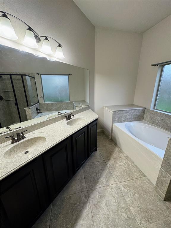 236 Archer Way Forney, TX 75126 - Photo 32 of 35 a bathroom with a double vanity sink a mirror and a bathtub