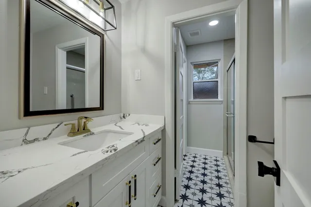 a bathroom with a granite countertop sink toilet and shower