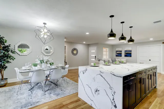 a living room with furniture a dining table wooden floor and a fireplace