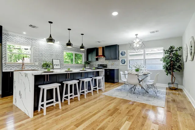 a large white room with kitchen view and wooden floor