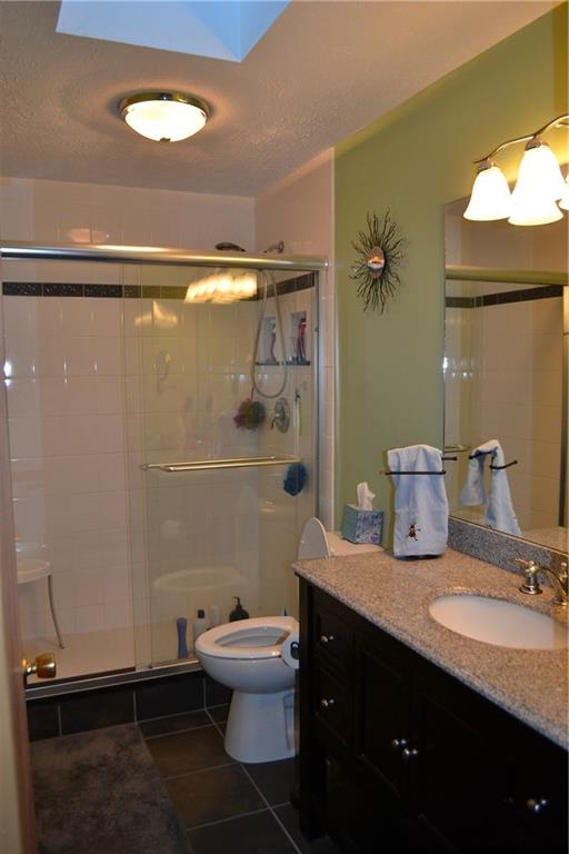 9252 Highland Road Pittsburgh, PA 15237 - Photo 12 of 17 Updated full bath with granite countertop, tile shower with in-lay, ceramic tile flooring and skylight.