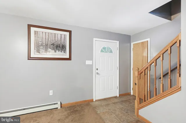 a view of a livingroom with a fireplace a chandelier and windows