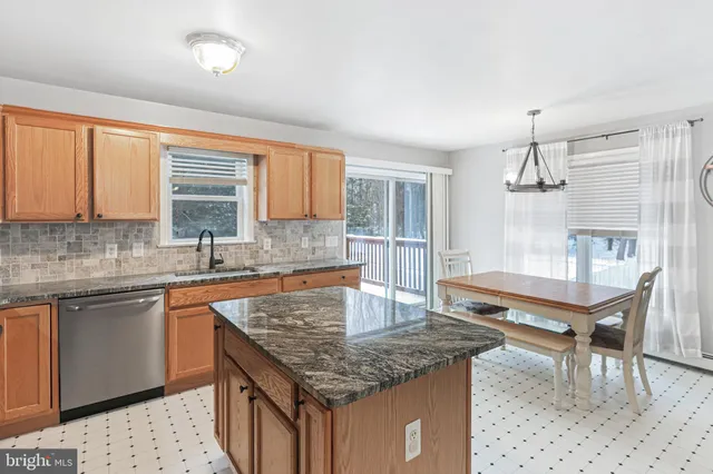 a kitchen with stainless steel appliances kitchen island granite countertop a refrigerator a sink a stove and island